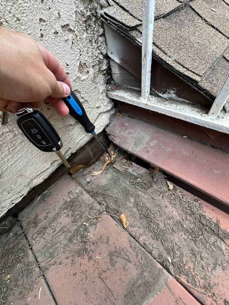 Balcony-to-stucco wall junction showing moisture damage